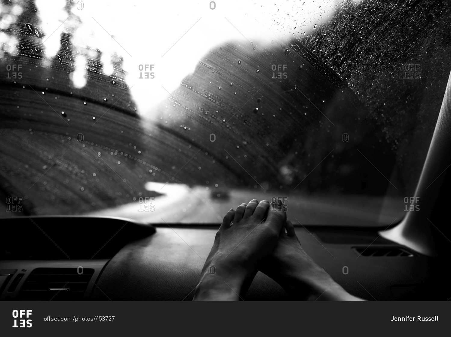 Woman's feet on the dashboard of a car while traveling stock photo OFFSET