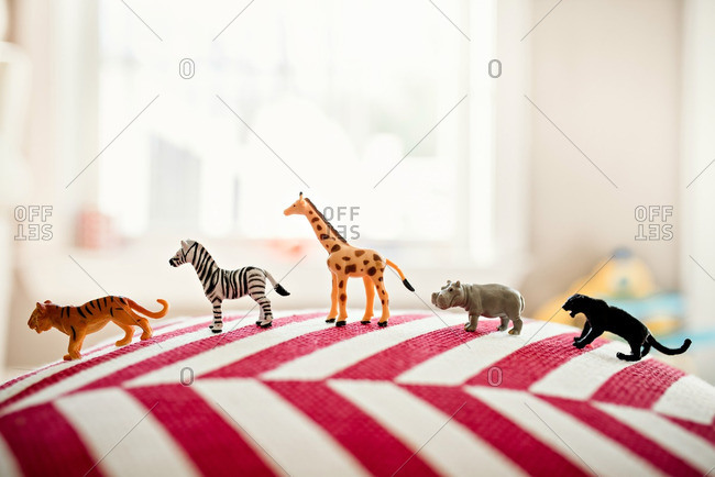 Animal toys lined up on pillow stock photo - OFFSET