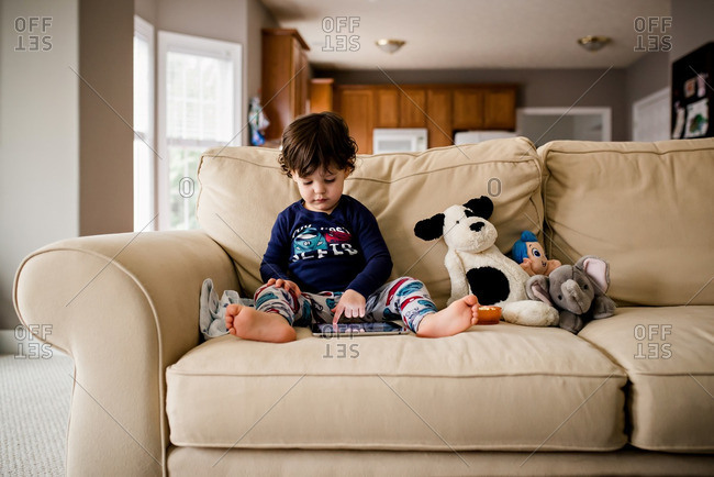 Boy using tablet by dolls
