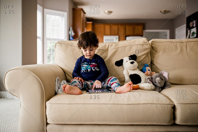 Boy using tablet by dolls