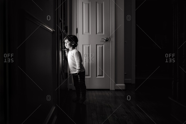 Toddler Boy Looking Through A Door Stock Photo Offset