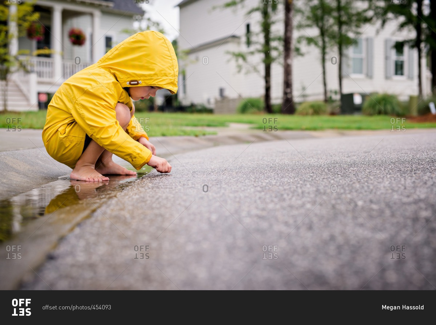 Boy in rain clothes exploring street