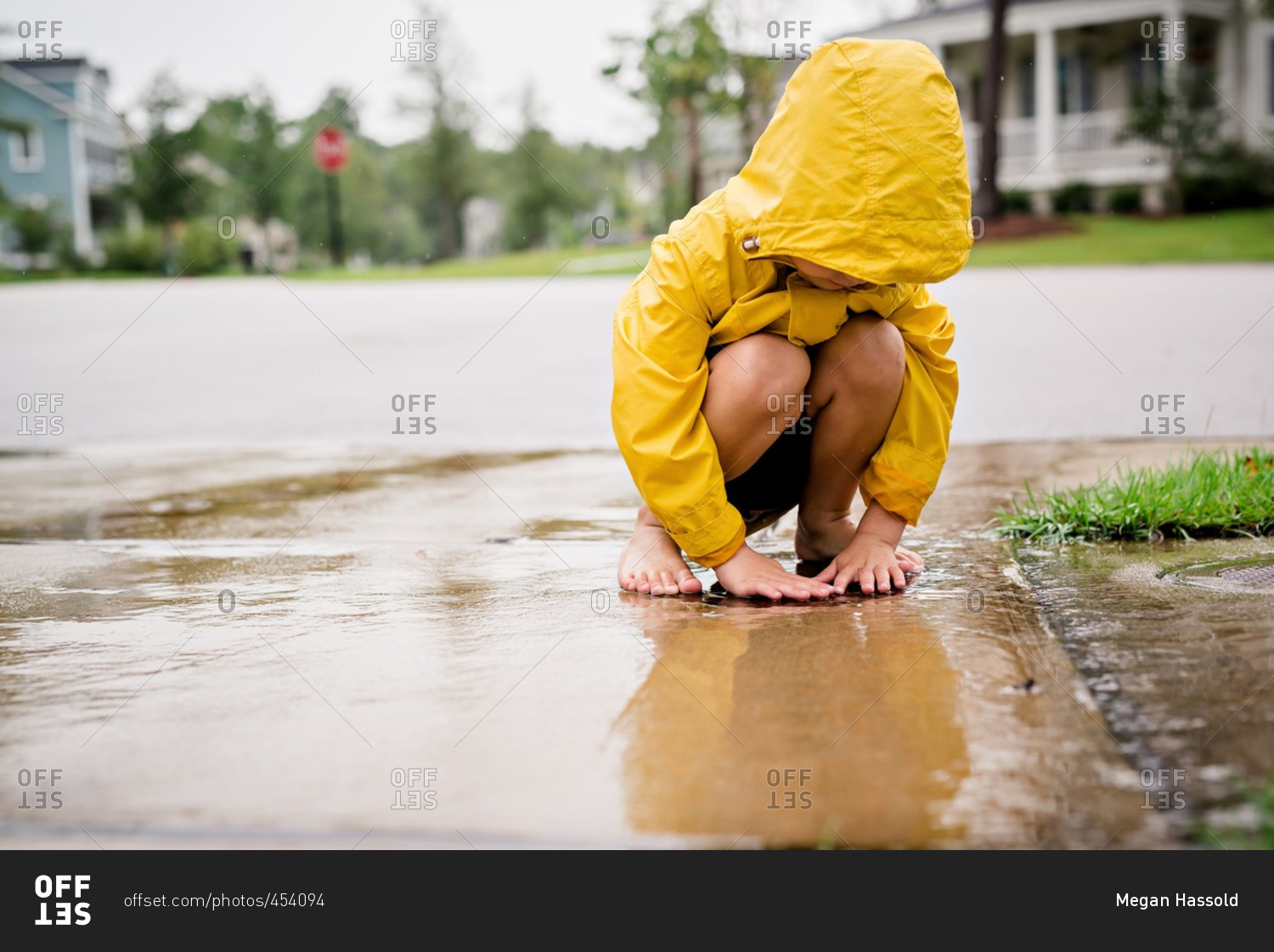 Boy playing in rain water on street