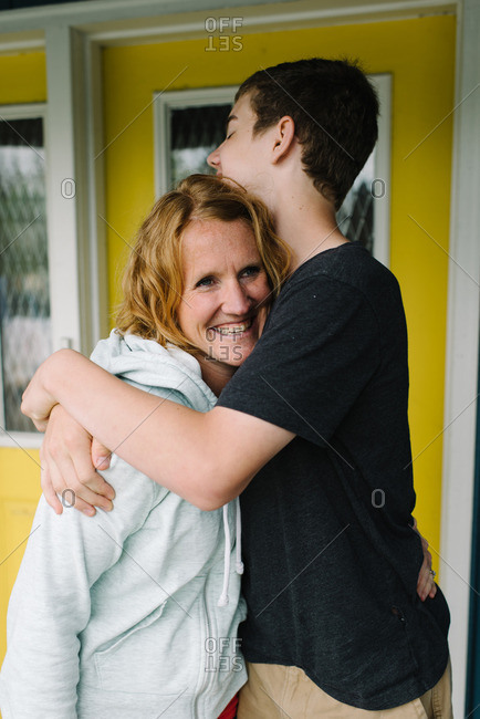 Teen Boy Giving His Mom A Hug Stock Photo - OFFSET