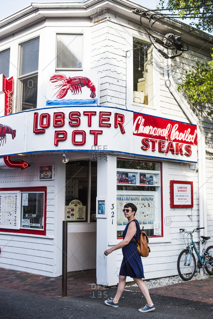 Provincetown, Massachusetts - June 12, 2015: Woman passing seafood restaurant