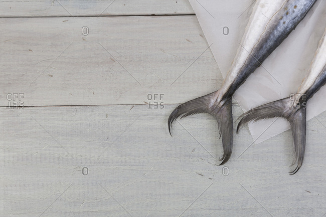 Tails of raw fish on a wooden table