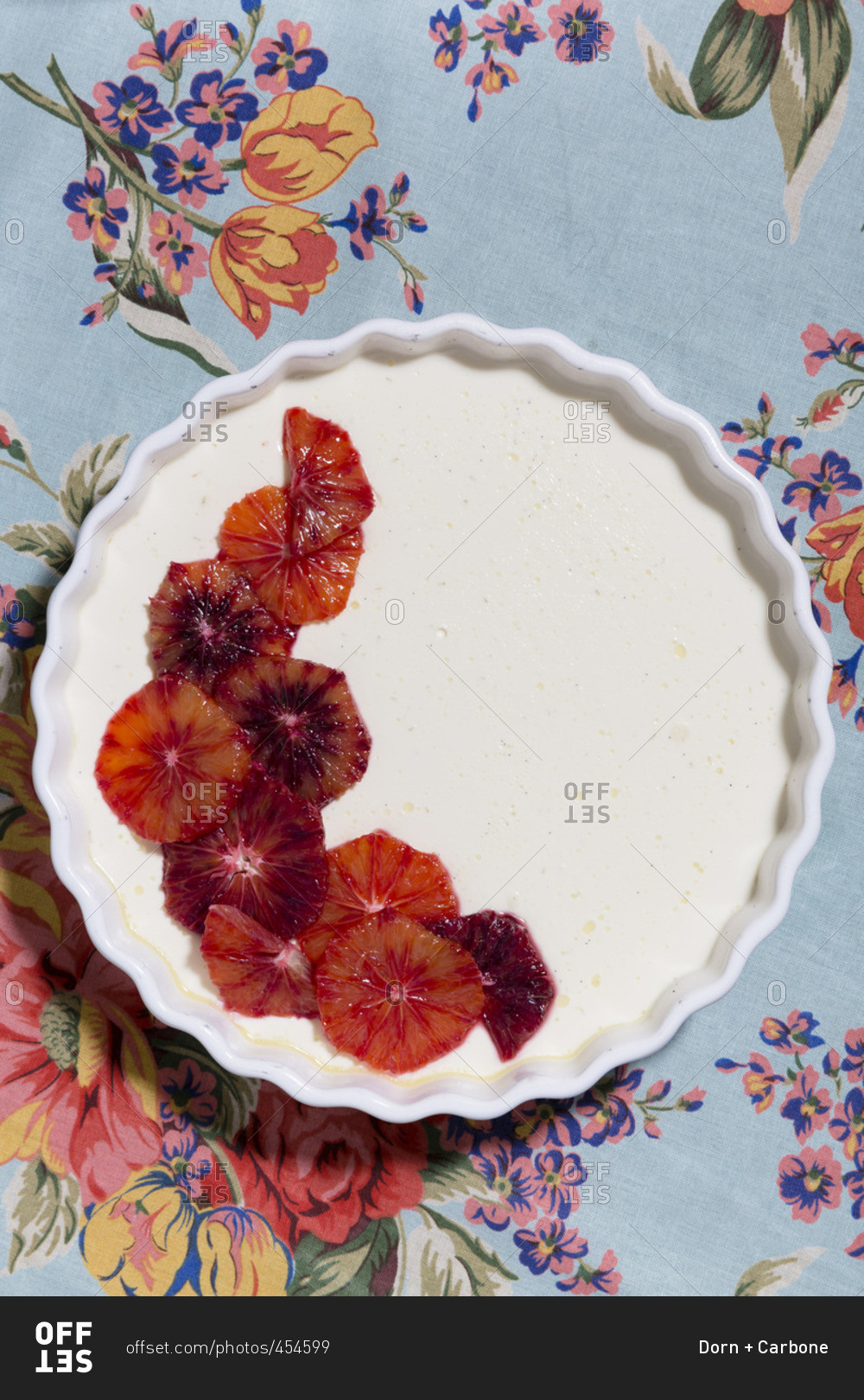 Blood orange dessert in a pie plate on a floral tablecloth