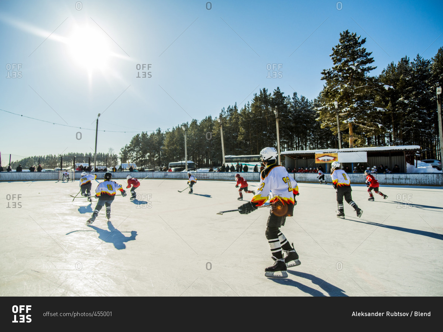 Caucasian boys playing ice hockey outdoors