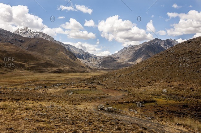 Dirt path in a valley and distant mountains in the Cordillera Blanca, Peru