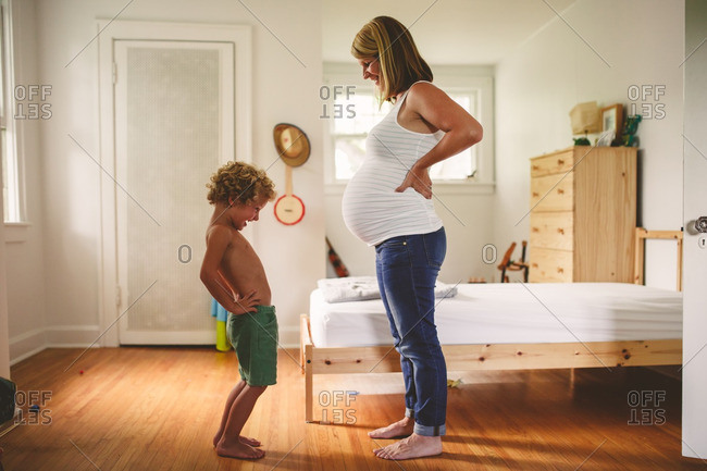 Boy sticking his stomach out to imitate his pregnant mother