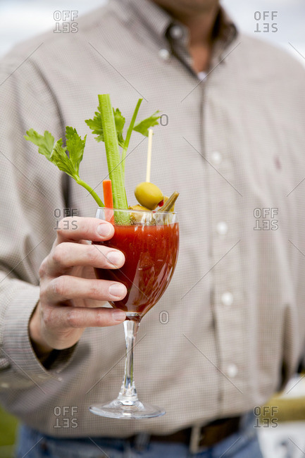 Close up of a man holding bloody mary