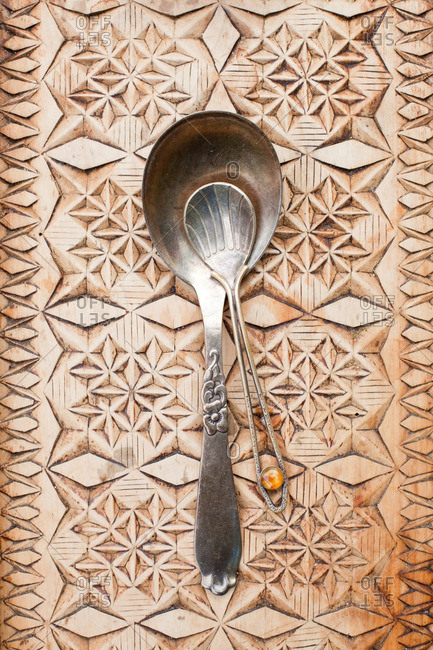 Antique serving spoon and teaspoon on a wooden tray