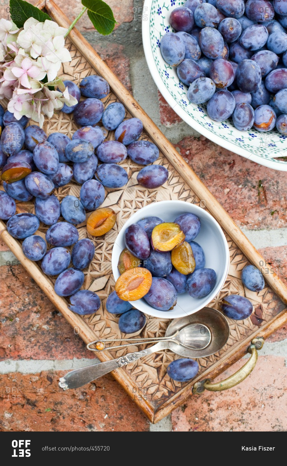 Plums in ceramic bowl and on a carved wooden tray