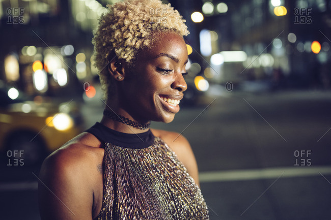 USA- New York City- portrait of happy young woman on Times Square at night