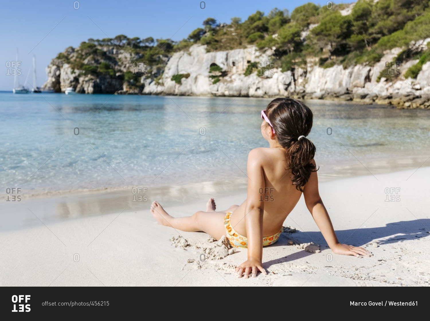 Little girl taking sunbath on the beach