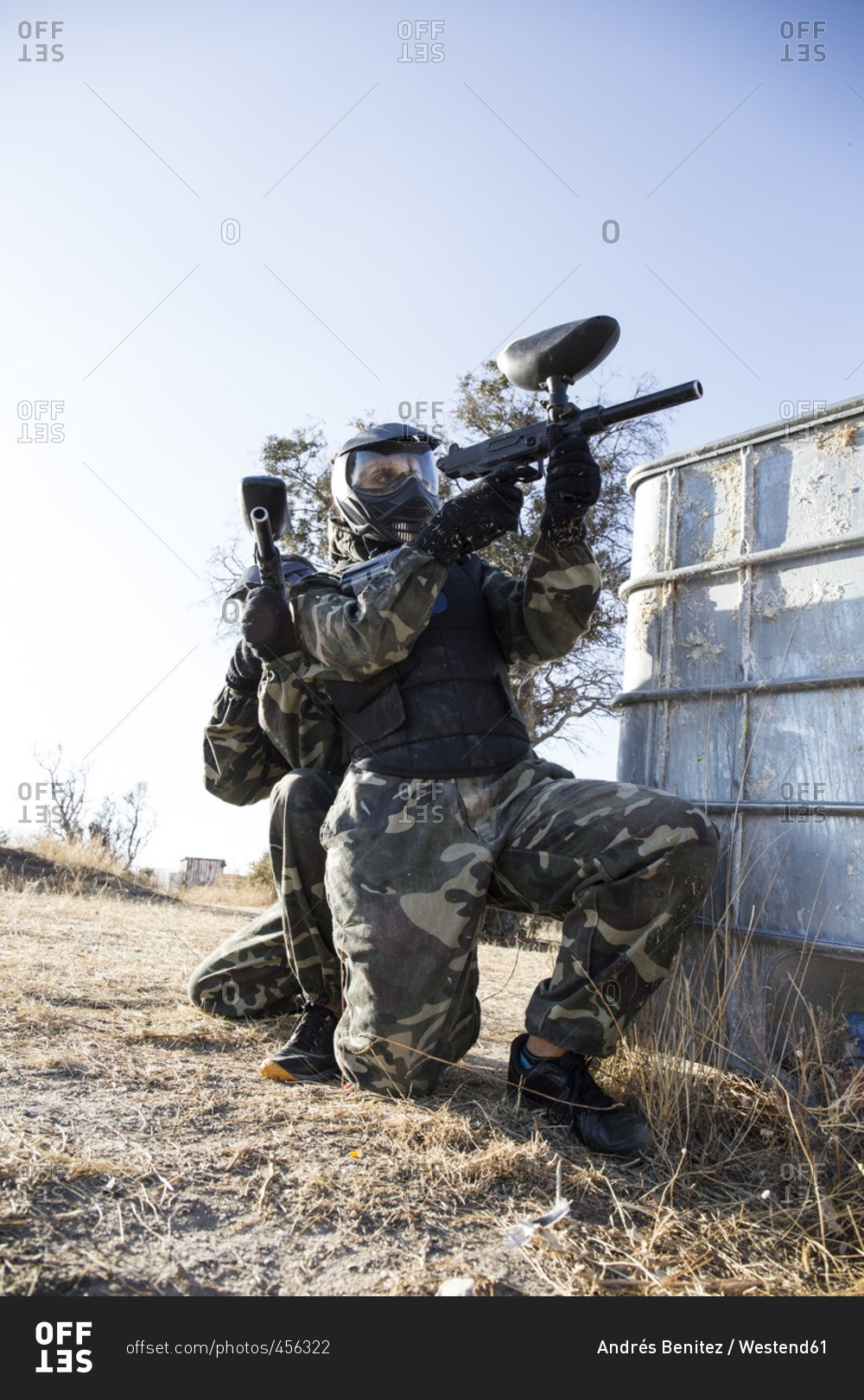 Paintball players aiming with paintball guns during a paintball game