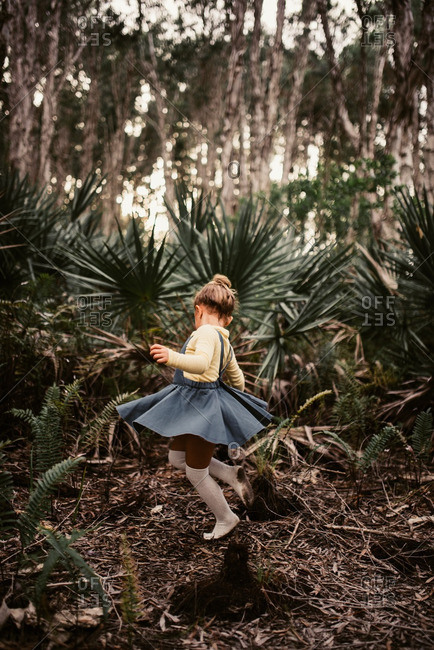 Little girl dancing in the woods