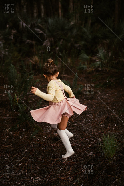 Little girl dancing in the forest
