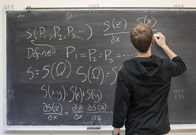 Caucasian student writing on blackboard