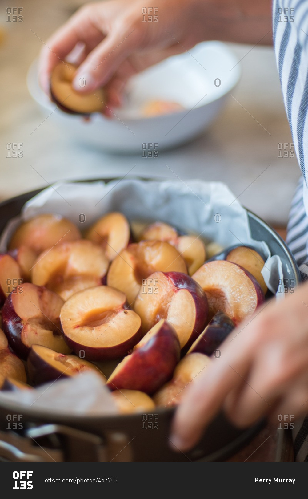 Putting plums into baking ring