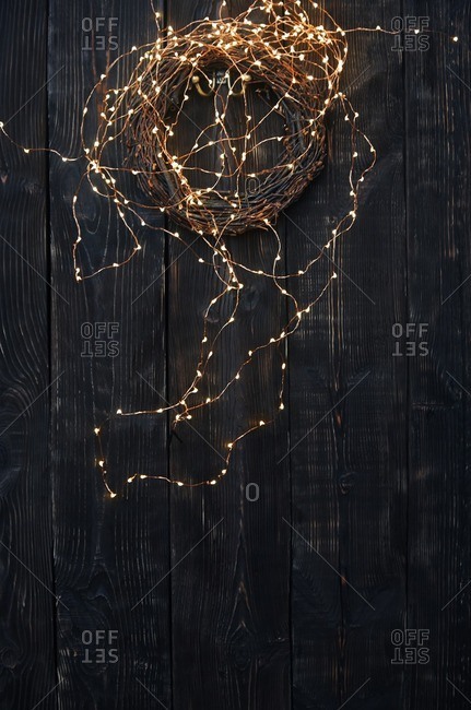 Christmas garland and fairy lights on a wooden wall
