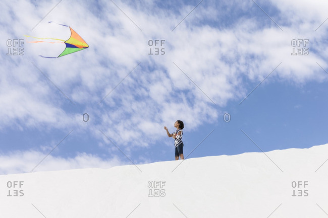 A young girl flying a cite at the White Sands National Monument