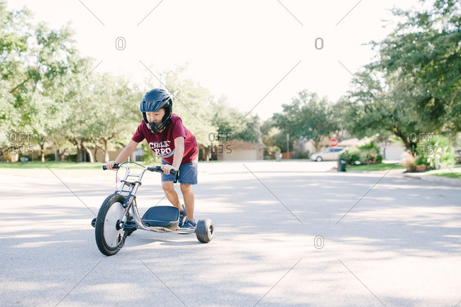 Boy playing on a low rider tricycle