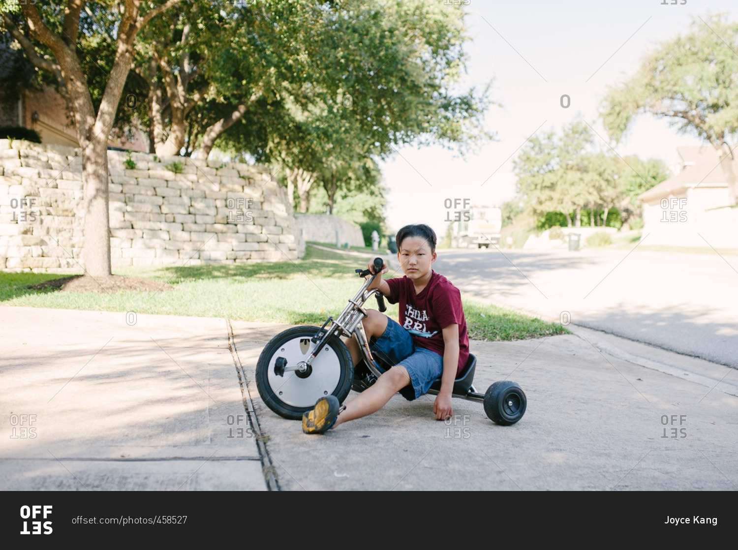 Boy sitting on a low rider tricycle