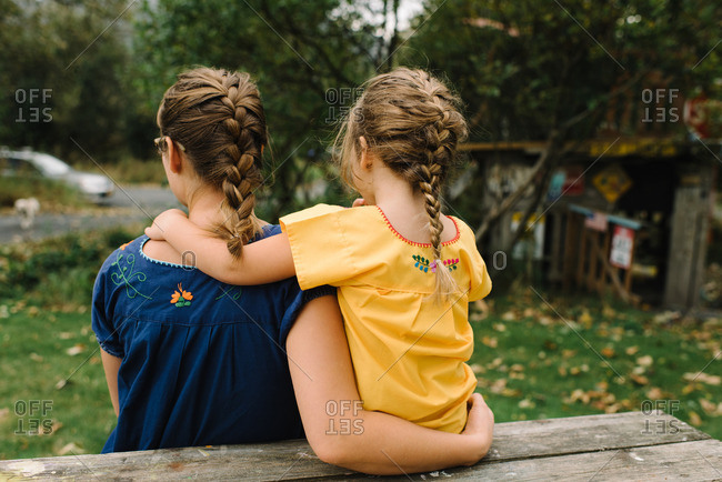 Mom holding girl wearing embroidered shirts
