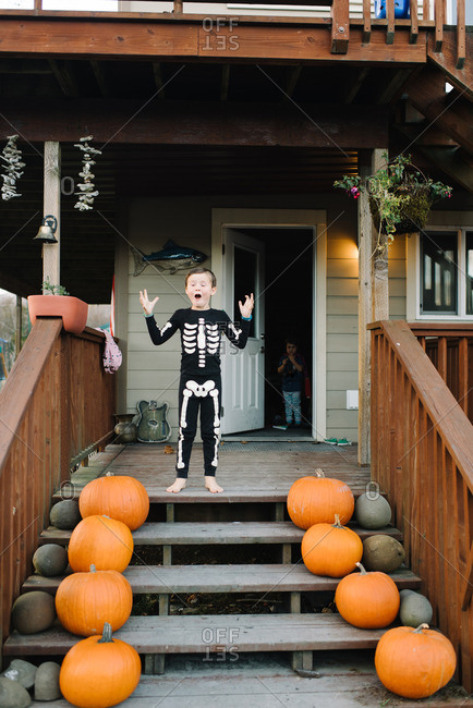Boy in skeleton pajamas on porch