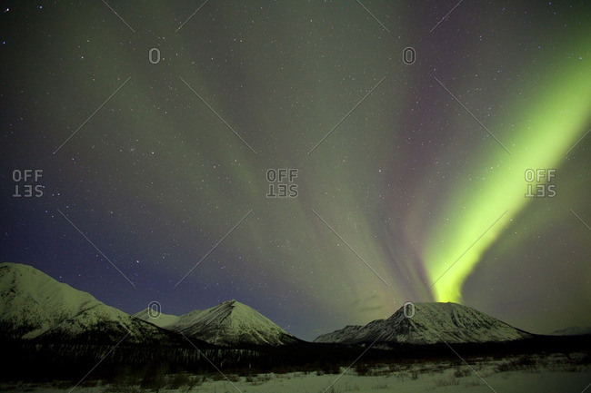 Aurora borealis or northern lights above the mountains outside of Whitehorse, Yukon Territory, Canada.
