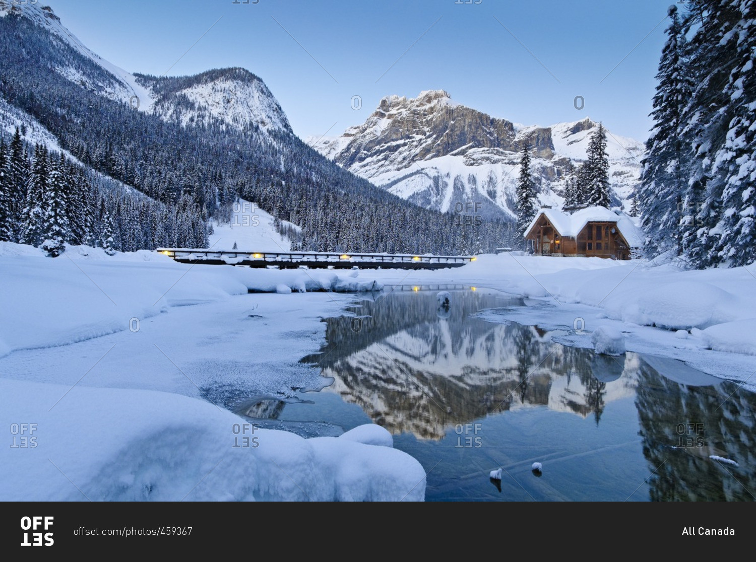 Restaurant of Emerald Lake Lodge complex, reflected in outlet stream at Emerald Lake, Winter, Yoho National Park, British Columbia, Canada