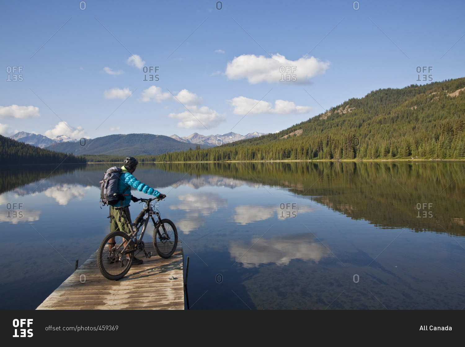 A male mountain biker enjoys a peaceful  moment in the morning before an all day ride in Spruce Lake Protected Area, Southern Chilcotins, British Columbia, Canada