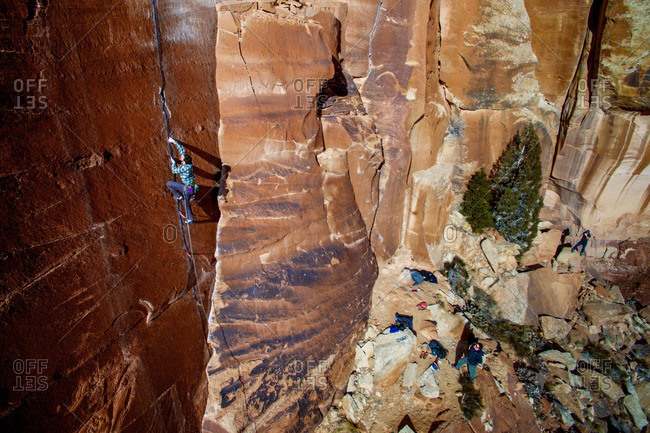 A man climbs sandstone cracks in the Colorado desert.
