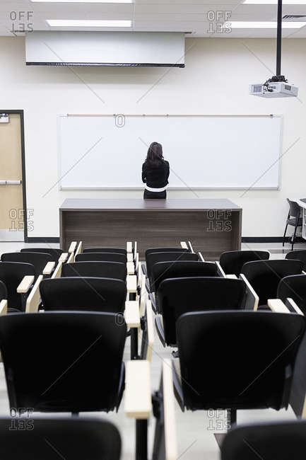 Caucasian teacher at whiteboard in empty classroom