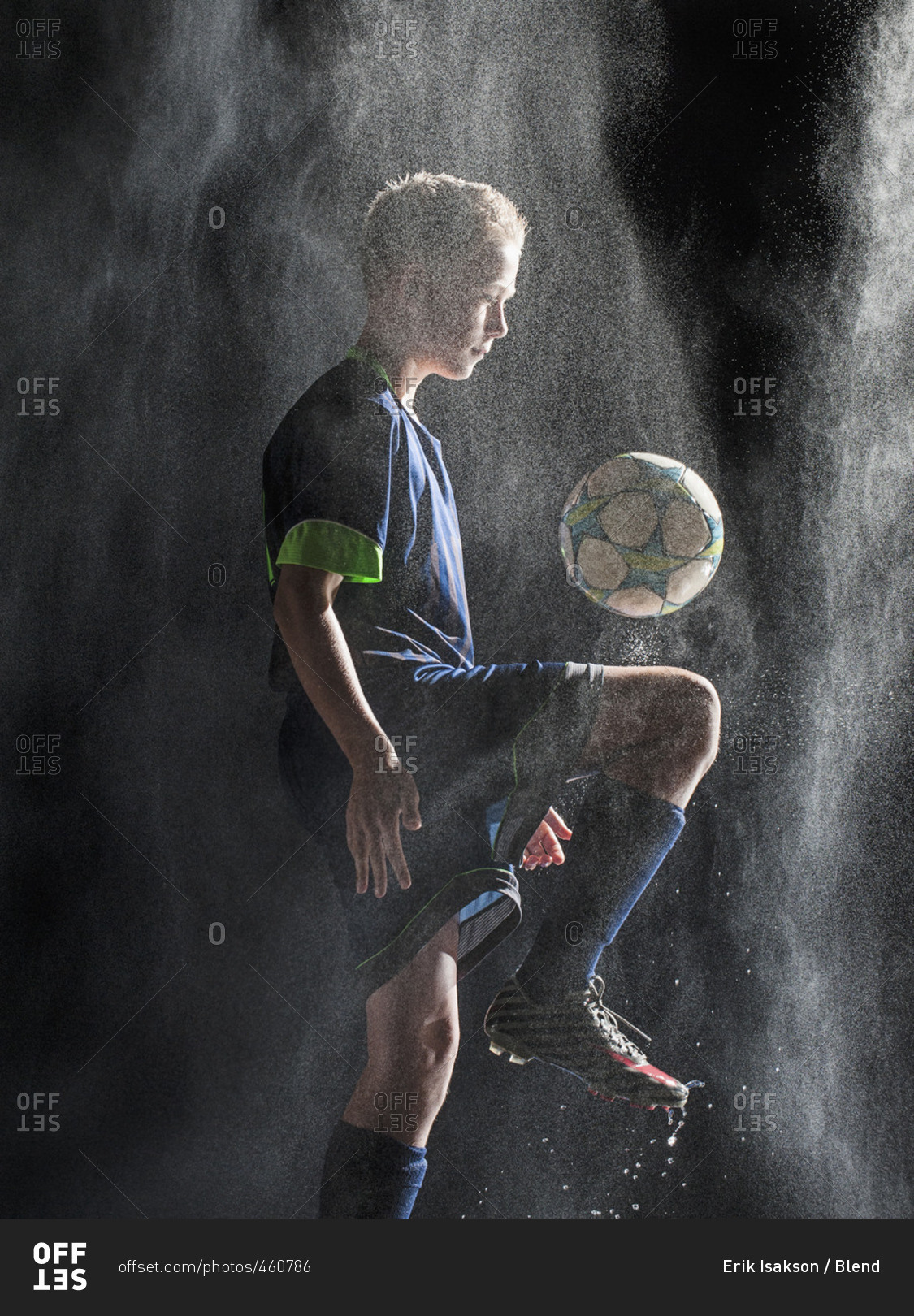 Caucasian soccer player kicking ball in rain