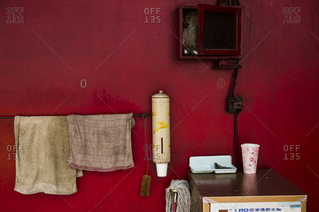 Red wall with dirty hanging hand towels, Tainan, Taiwan