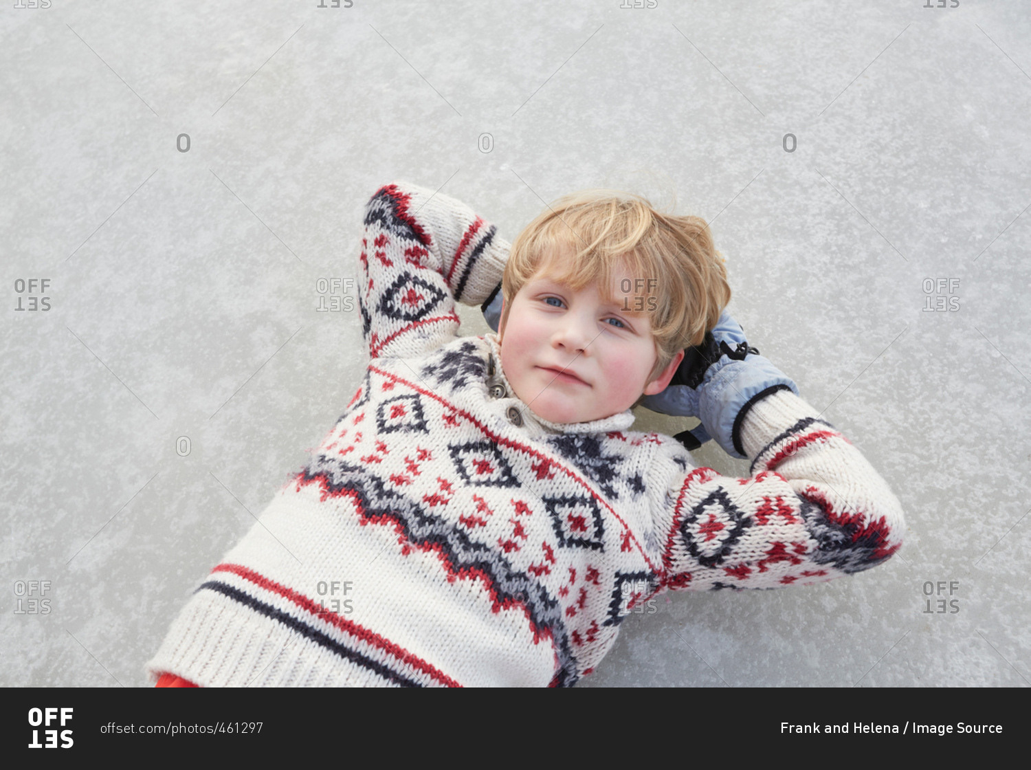 Overhead portrait of boy lying on frozen lake, Gavle, Sweden