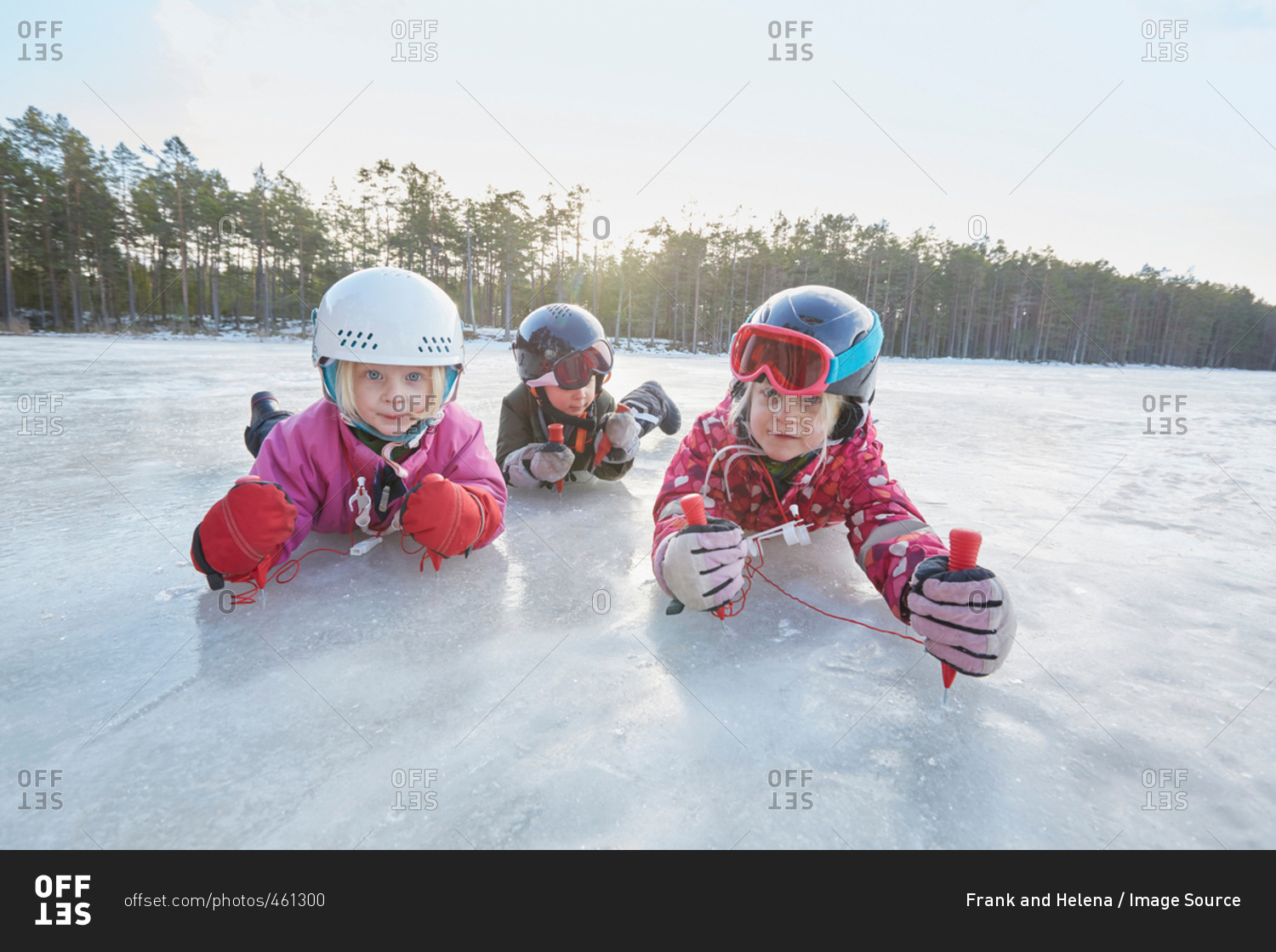 Portrait of girls and boy crawling on frozen lake, Gavle, Sweden