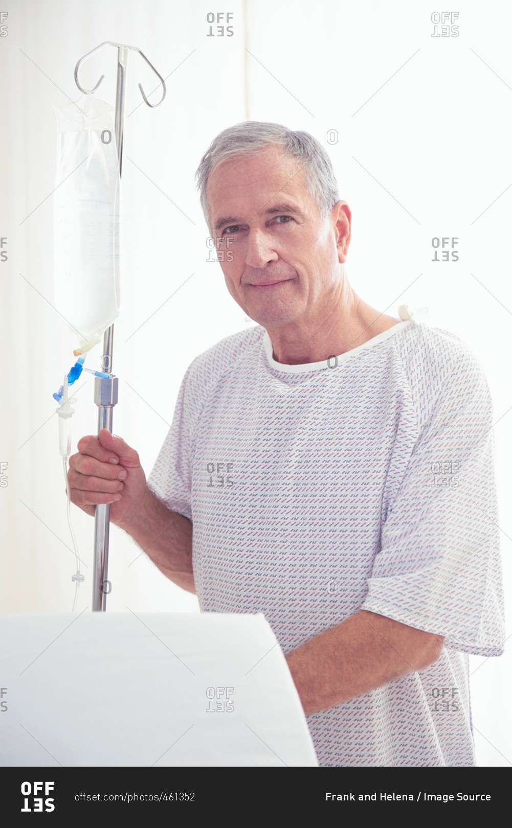 Portrait of senior male patient holding intravenous drip in hospital