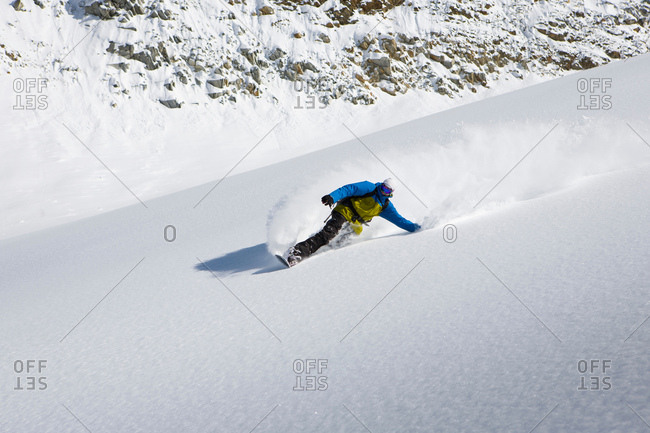 Male snowboarder snowboarding down steep mountain, Trient, Swiss Alps, Switzerland