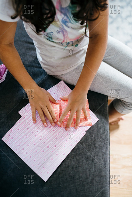 Girl making an origami craft with pink paper