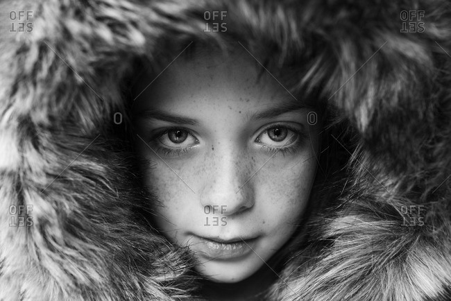 Close-up portrait of young child in fur hood