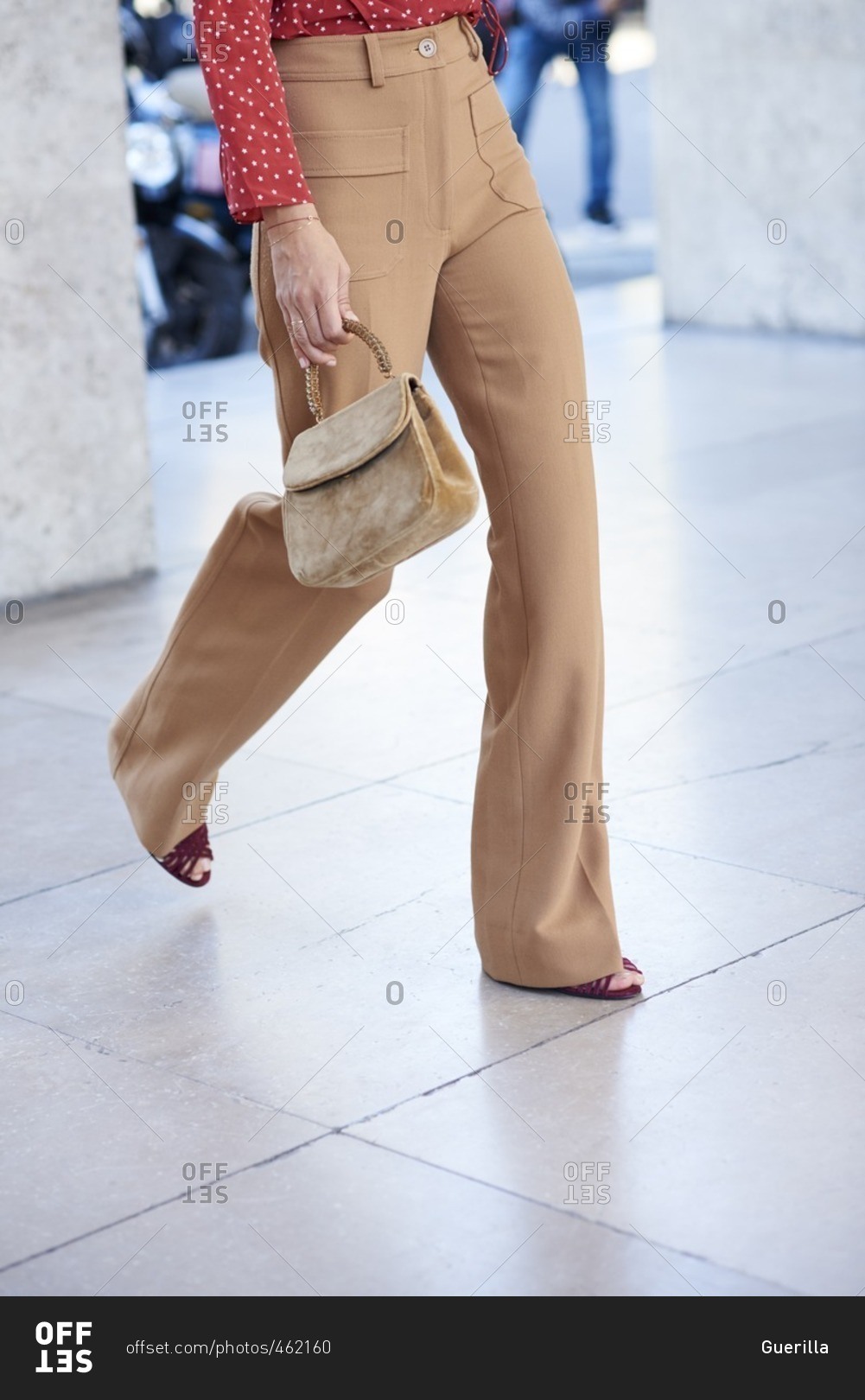 Woman walking in fawn flares and red blouse
