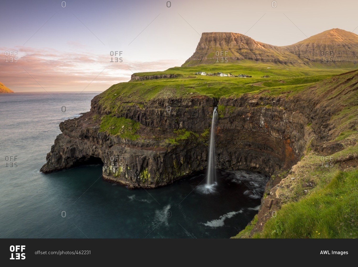 Gasadalur, Vagar island, Faroe Islands, Denmark. The iconic waterfall jumping from the cliff into the ocean.