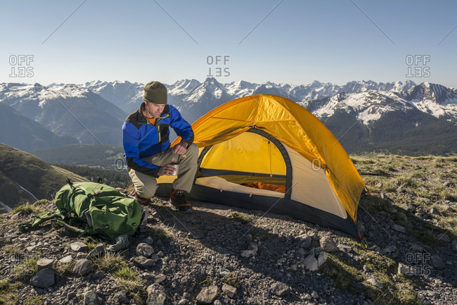 A Man With A Cup Of Tea Camping On A Ridgeline Above Molas Pass In San Juan National Forest, Durango, Colorado