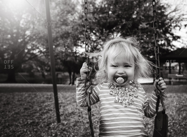 Girl on swing with pacifier