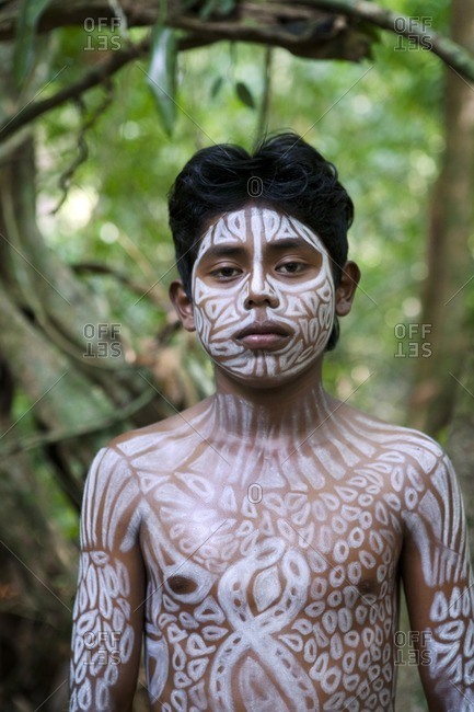 Hispanic boy with painted body in jungle, Lago Izabal, Guatemala
