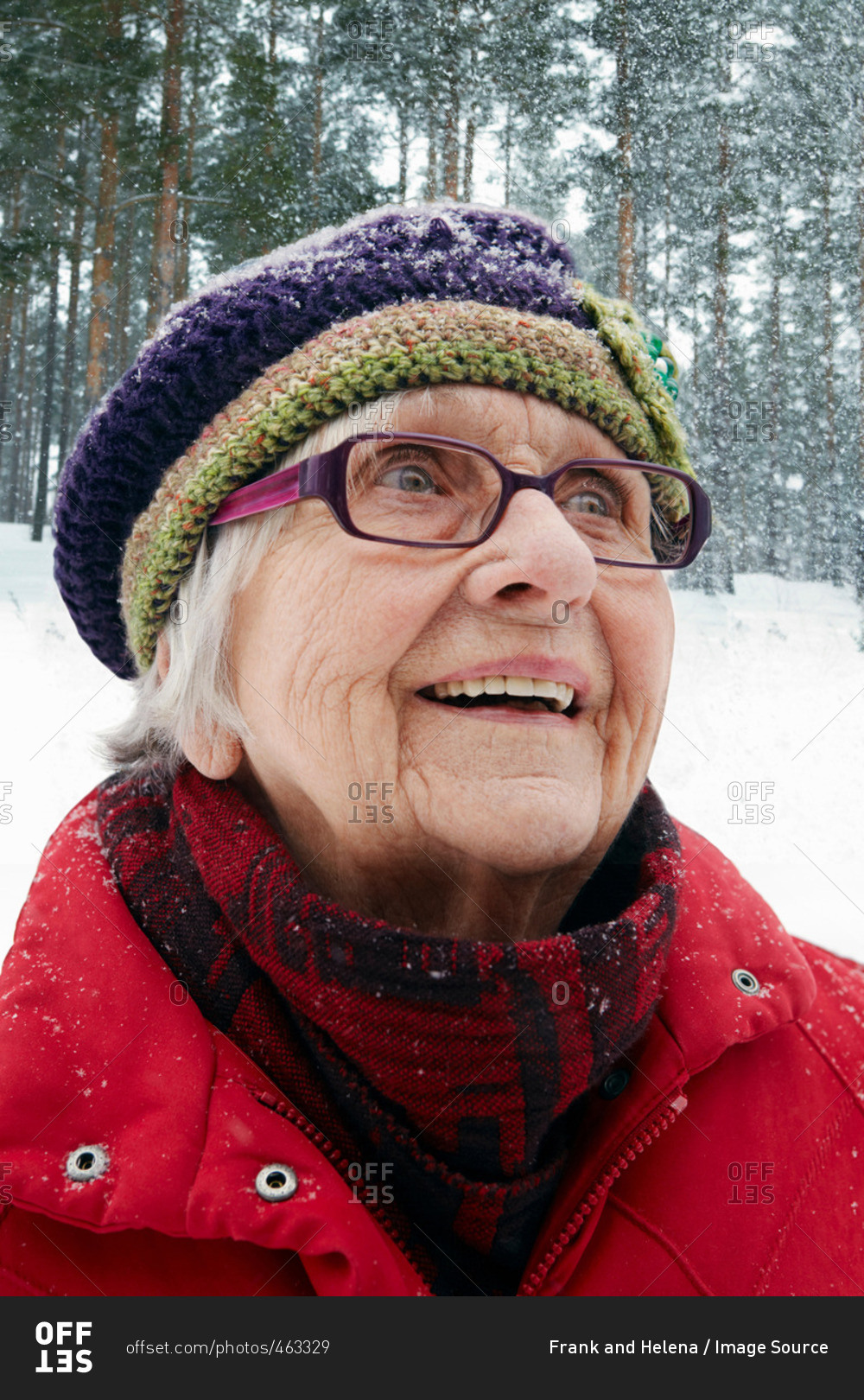 Smiling older woman watching snow fall