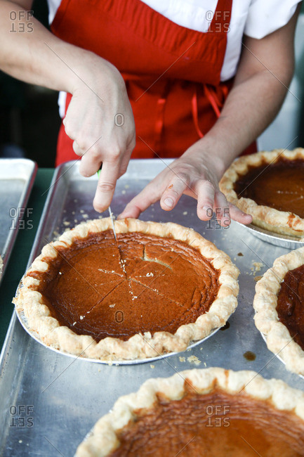 Baker slicing sweet potato honey pie in bakery